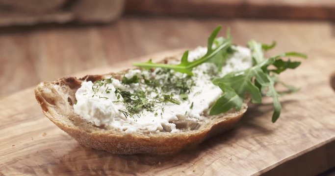 Slow motion of arugula fall on rustic bread with ricotta cheese, 4k 60fps prores footage