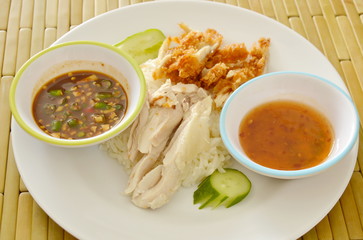 boiled and deep fried chicken on cooked rice with different dipping sauce on plate