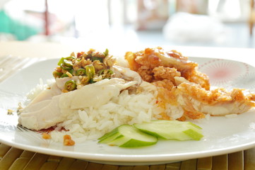 boiled and deep fried chicken on cooked rice dressing different sauce on dish
