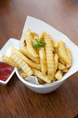 French fries in a bowl on a wooden table