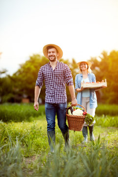 Farmers couple returning from garden with vegetables