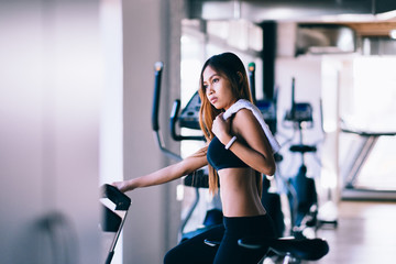 Fototapeta premium Sport young woman on a stationary bike in the gym