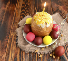 Easter color eggs, Easter cake and the burning candle are a holiday symbol.