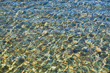 The water in the pool has a tile bottom tile glittering in the sun. Background, texture