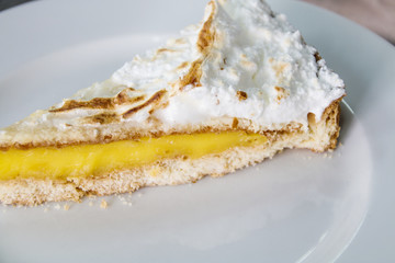 A slice of lemon cake with meringue.