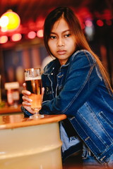 Young beautiful woman drinking beer in a bar