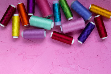 Colored thread on a pink background
