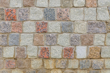 A fragment of a stone cobbled wall. Background, texture