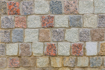 A fragment of a stone cobbled wall. Background, texture