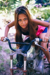 Obraz premium Young beautiful girl posing on the old rusty motorbike