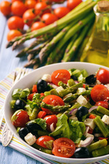 Vegetable salad with asparagus, tomatoes, feta cheese and olives.