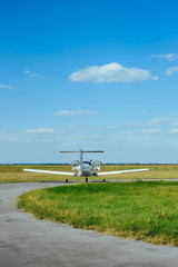 Fototapeta premium Gray airplane parked on the grass at the airfield