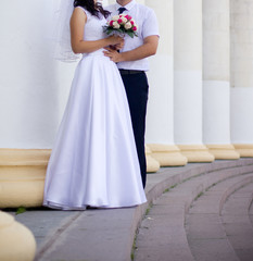 Plakat Bride and groom holding wedding bouquet with roses