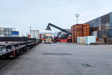 Container stacker unloads trucks.