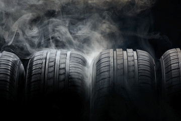 Car tires and smoke on black background