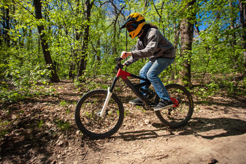 young man ride mountain bike through forest
