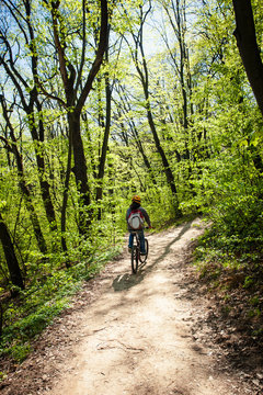 man ride mountain bike through forest