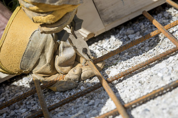 Worker tying steel reinforcing rods with string