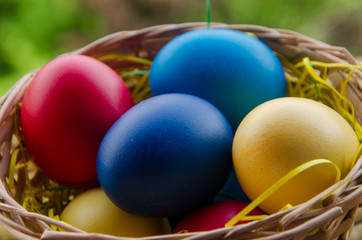 Fototapeta na wymiar Colourful Easter Eggs in basket with bokeh background