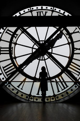 Naklejka premium Woman silhouette standing in front of large clock