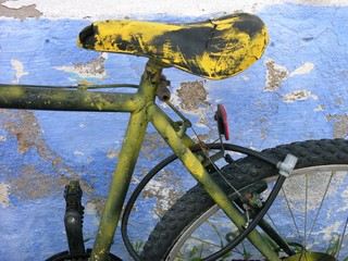 Bemaltes buntes Fahrrad mit Grün und Gelb vor bröckelnder hellblauer Fassade in den Gassen der...