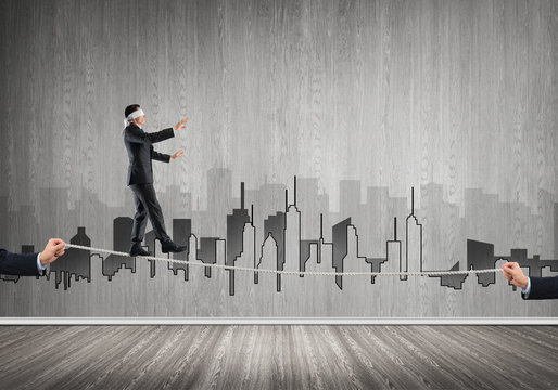 Business concept of risk support and assistance with man balancing on rope