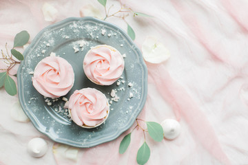 Cakes with cream on a gray plate. Flat lay, top view