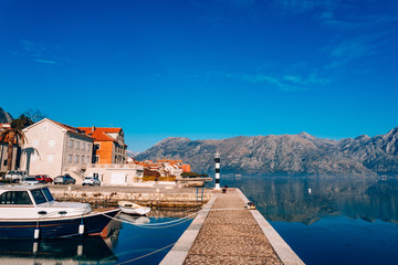Fototapeta na wymiar Black and white lighthouse in the sea. Prcanj, Kotor Bay, Montenegro.