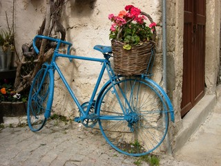 Blaues Rennrad mit Blumenkorb auf dem Gepäckträger in den Gassen der Altstadt von Alacati in der...