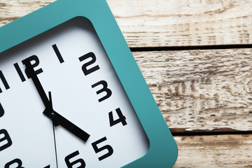 Green clock on a grey wooden table