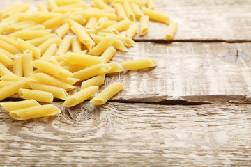 Pasta penne on the brown wooden table