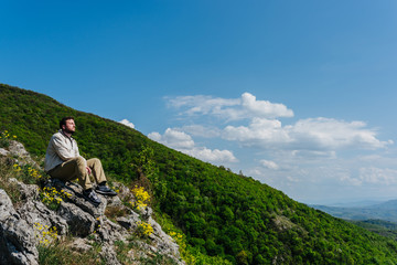 Naklejka na ściany i meble Meditating on a cliff with nature in background
