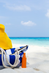 Summer hat and blue stripe bag on beach