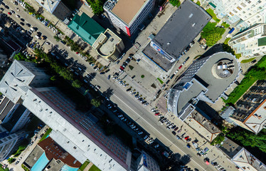 Aerial city view with crossroads and roads, houses, buildings, parks and parking lots, bridges. Copter shot. Panoramic image.