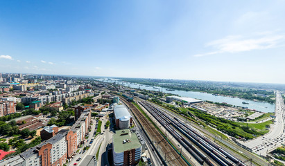 Obraz premium Aerial city view with crossroads, roads, houses, buildings, parks and parking lots. Copter drone helicopter shot. Panoramic wide angle image.