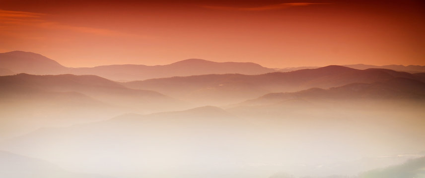 Fototapeta Mountain layer in morning sun ray and winter fog