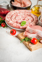Foods high in animal protein. Selection of meat. Healthy food. Raw foods, ingredients. Chicken fillet, chicken wings and legs, beef steak, pork steak, homemade sausage. On white copy space