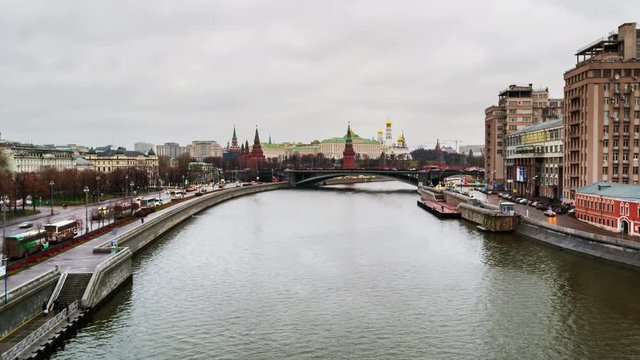 Moscow, Russia day to night time-lapse. River with aerial view of illuminated popular landmark in Moscow - Kremlin in Russia. Colorful cloudy sky. Touristic boats and car traffic