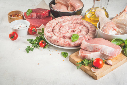 Foods high in animal protein. Selection of meat. Healthy food. Raw foods, ingredients. Chicken fillet, chicken wings and legs, beef steak, pork steak, homemade sausage. On white copy space