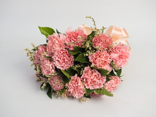 Woman hands holding a flower in green meadow, with focus on a flower. Pink Flower and nice ribbon.Pretty girl in a jeans dress on white background.