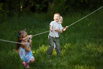 Naklejka na ściany i meble children pulling the rope outdoors