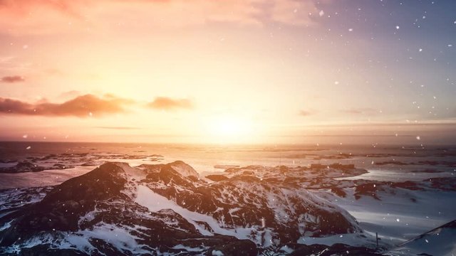 Antarctic Nature. Stony island in ocean. Beautiful colorful sunset cloudy sky. Snow falling. Majestic winter landscape. Beauty world, holidays, sports and recreation. Travel background. Slow motion 4K
