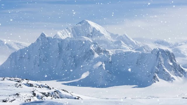 Antarctic Nature. Snow-capped mountains against blue cloudy sky with snow falling. Majestic winter landscape. Exploring beauty world, holidays, sports and recreation. Travel background. Slow motion 4K