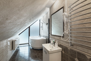 Bathroom rooms in the hotel with jacuzzi and sink. White walls, heated towel rail and a window