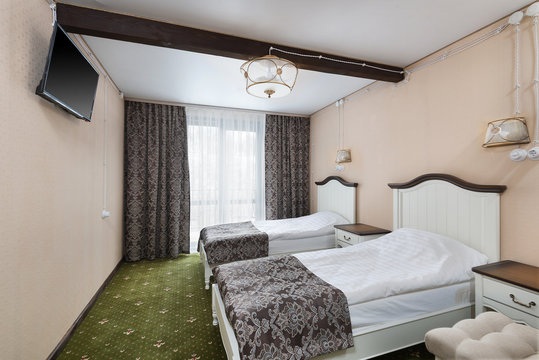 Classic Bedroom In A Hotel With Two Separate Beds. Modest But Cozy Atmosphere, Daylight, TV