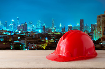 red safety helmet with night modern city building background