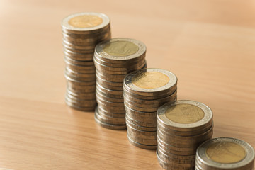 growing of gold coins stack on green leaves background