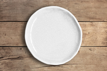 Blank white dish on a wood background.