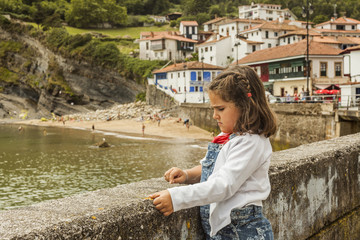 Girl watching seascape resting in the wall. Asturias. Spain