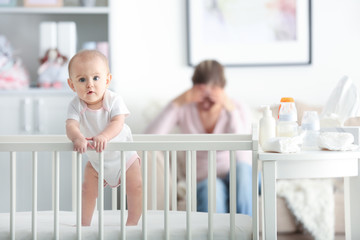 Depressed young woman with cute baby at home